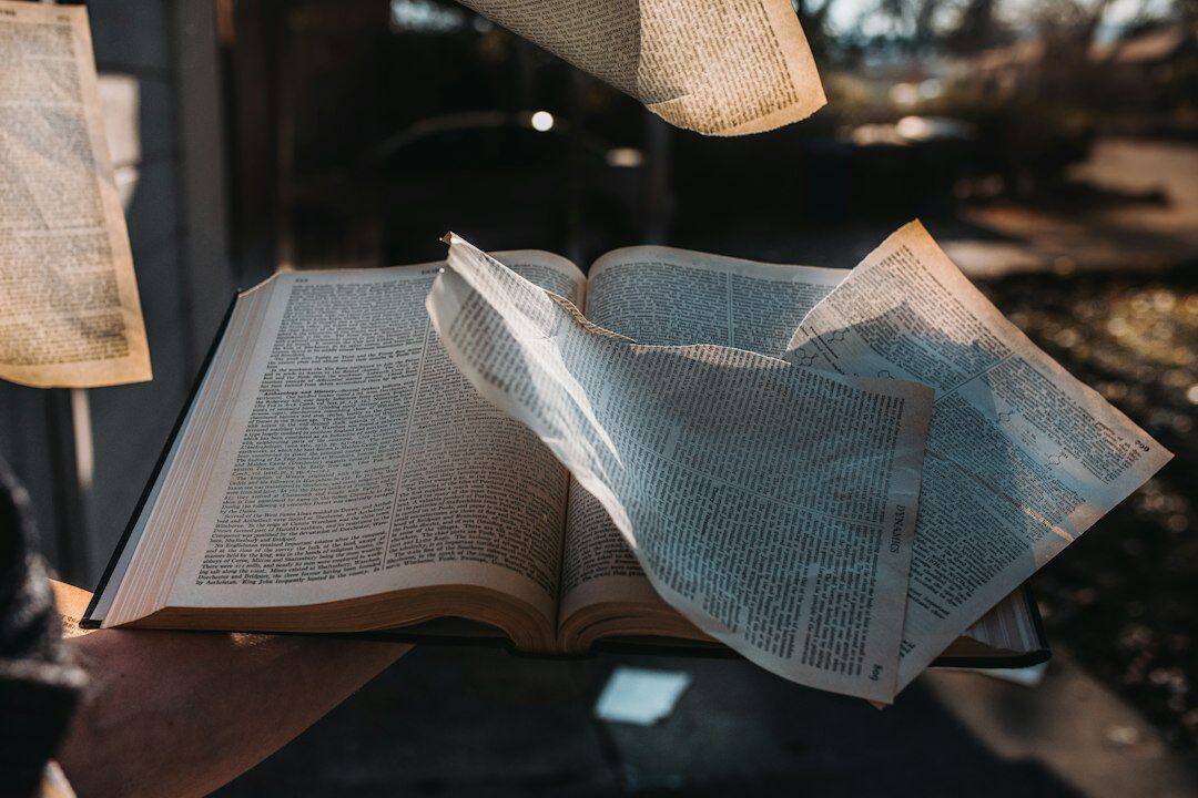 Close-up of open book pages with a magnifying glass