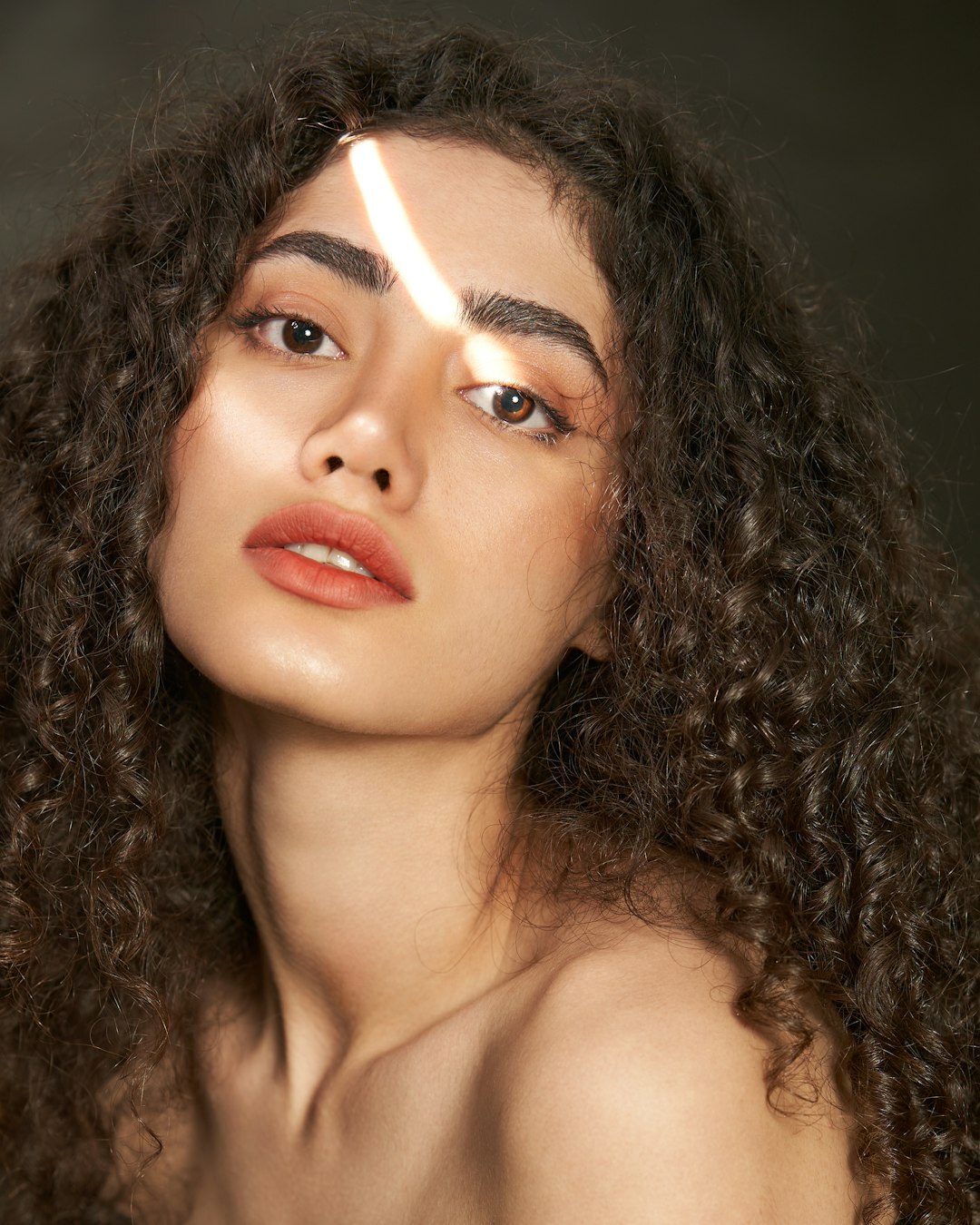 Studio portrait of a young Latina woman with curly hair