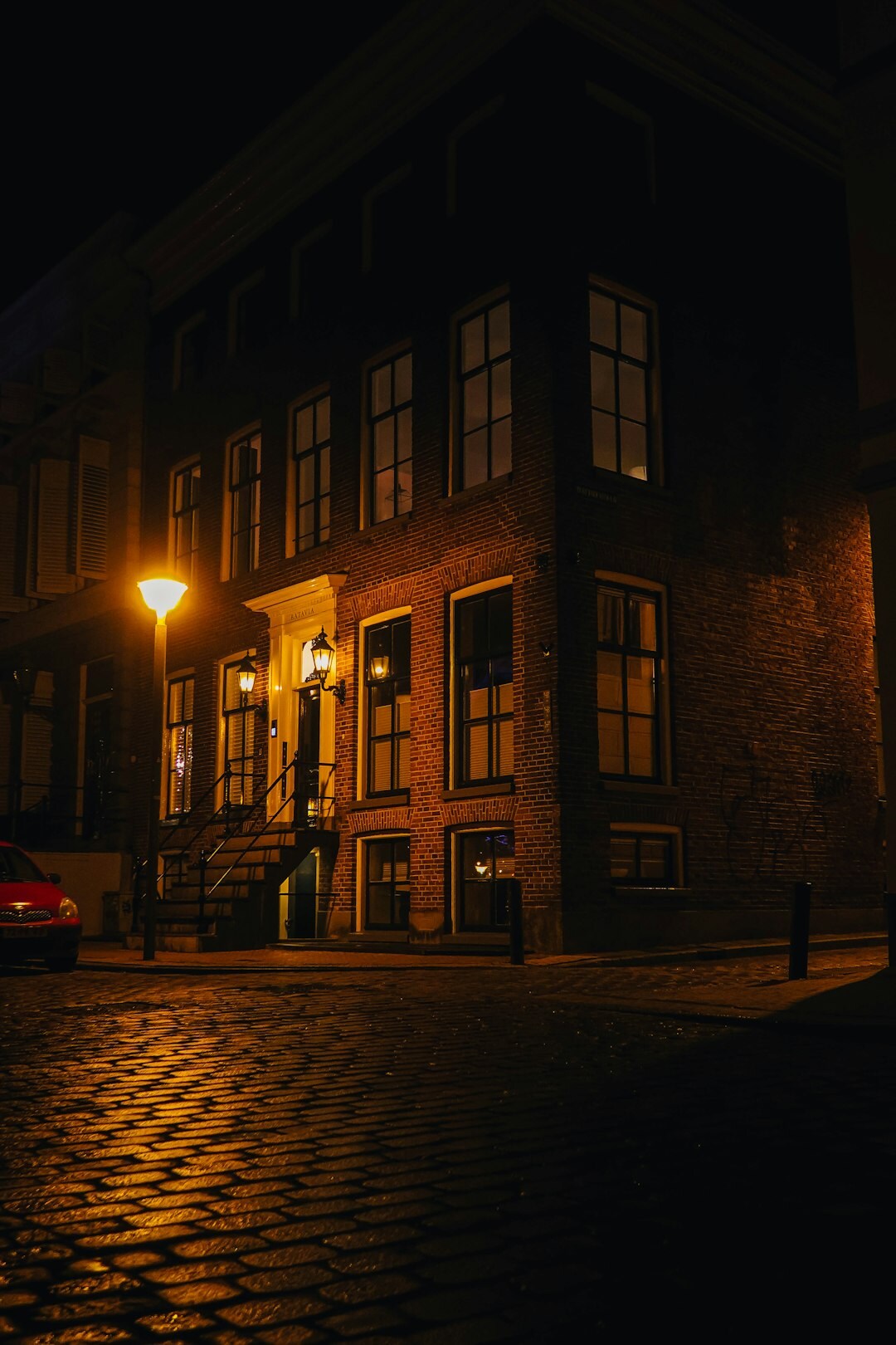 Foggy cobblestone street with a vintage lamp post at night