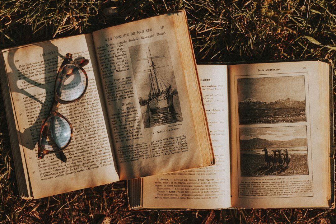 Stack of mystery novels with a magnifying glass on a wooden table