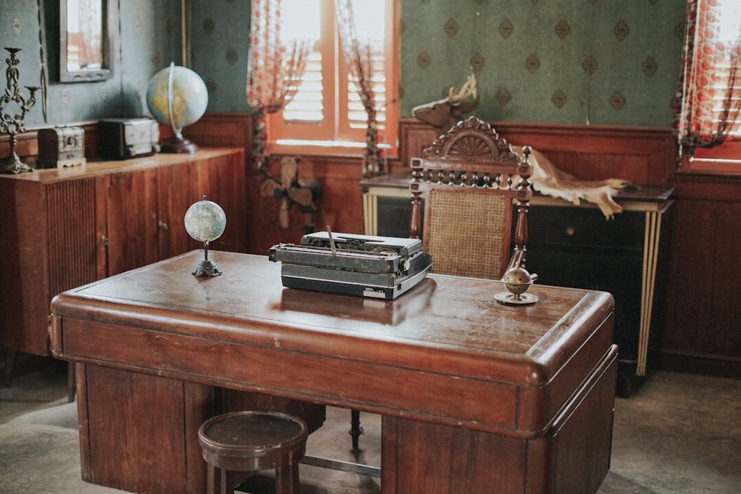 Vintage wooden desk with typewriter, books and a lamp