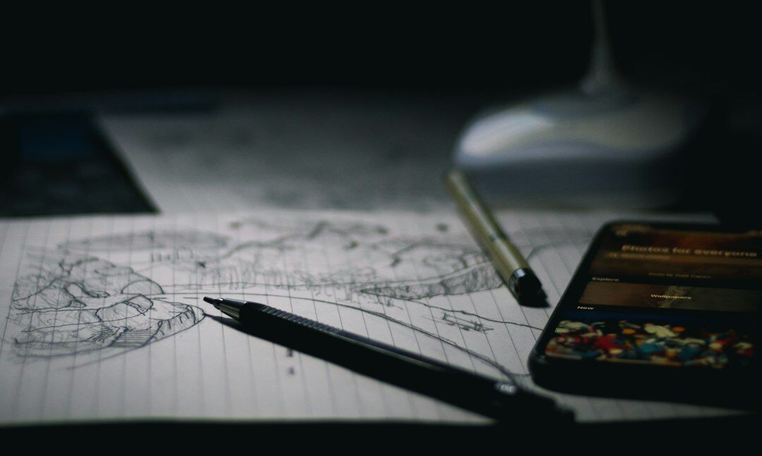 Open notebook with a pen and magnifying glass over an old map