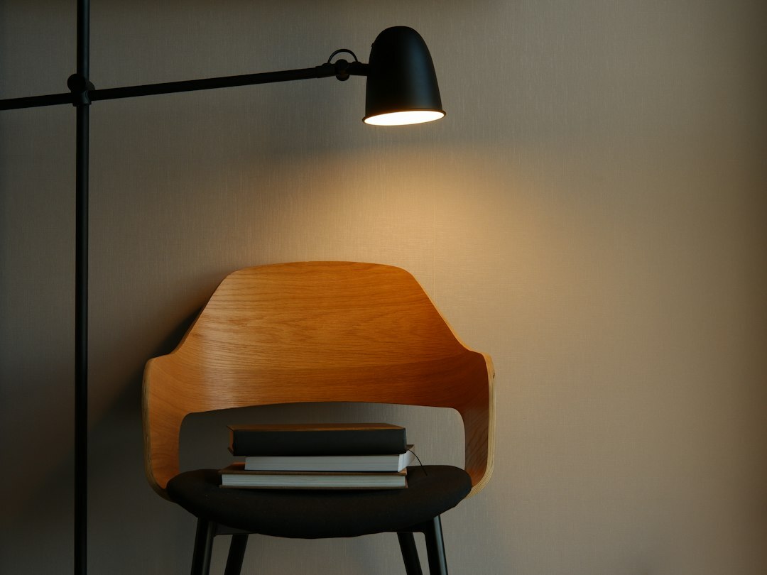 Cozy reading chair with an open book under warm lamp light